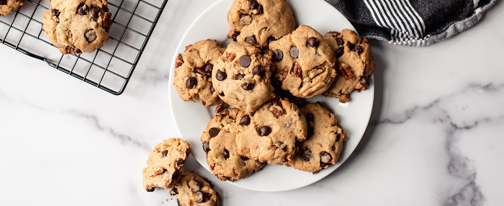 Cookies mit Schokoladenstücken auf weißem Teller