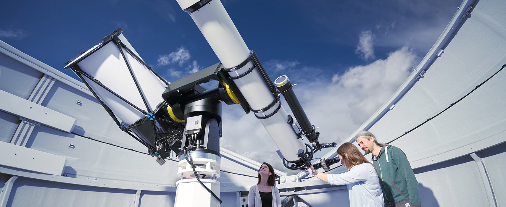 Personen sehen durch das Teleskop auf Sterne und ferne Galaxien