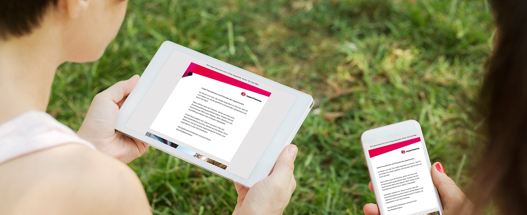 Schulterblick auf Tablet und Smartphone mit experimenta Newsletter am Screen