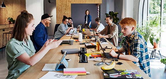 Junge Menschen mit Laptops am Tisch im Maker Space