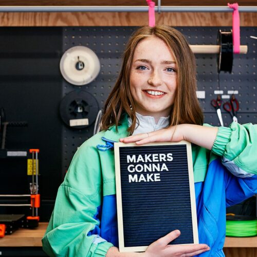 Mädchen mit Texttafel im Maker Space