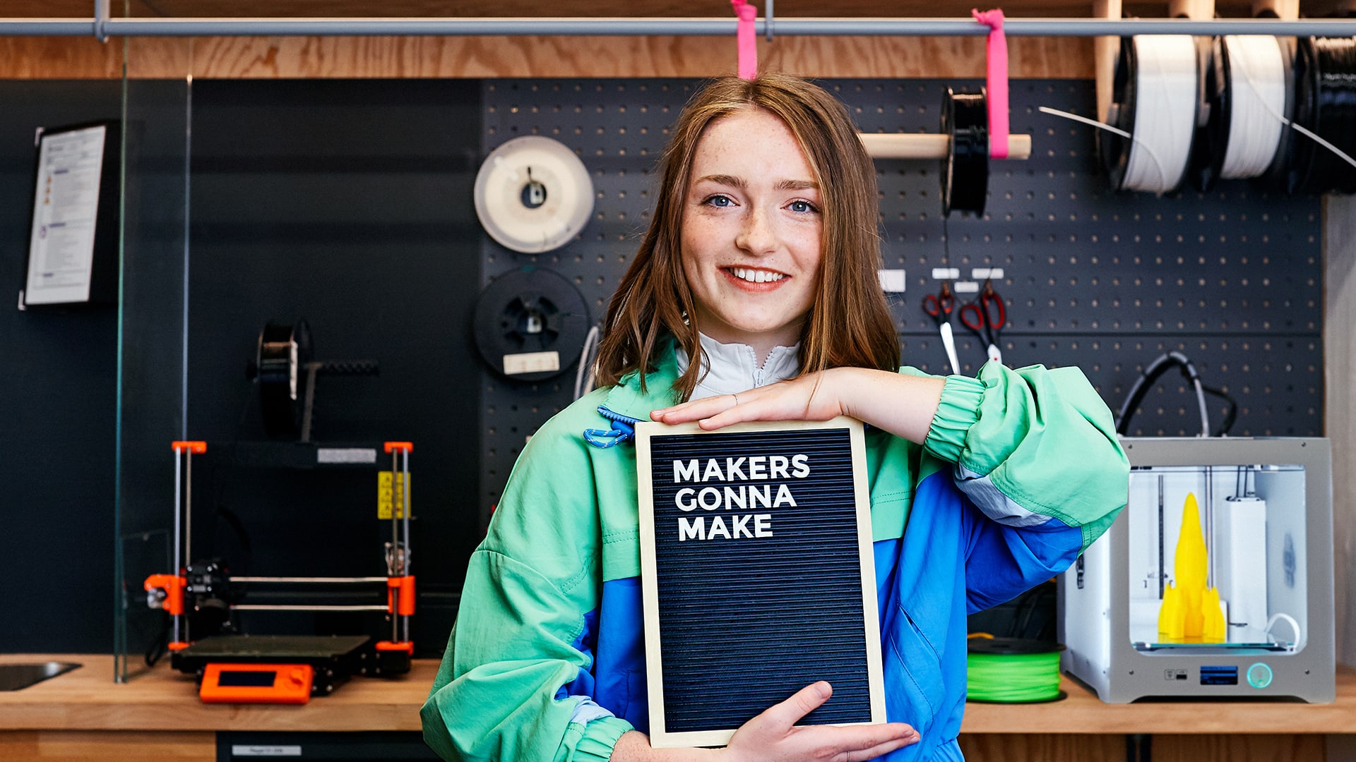 Mädchen mit Texttafel im Maker Space