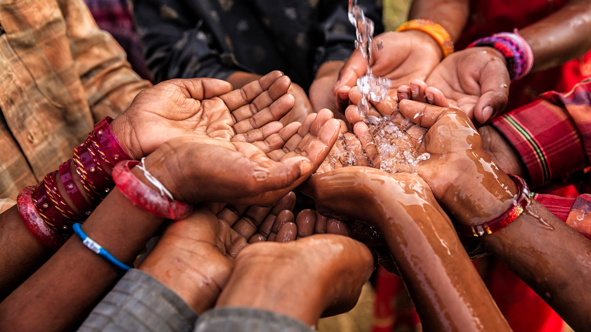 Wasser regnet auf Gruppe von Händen