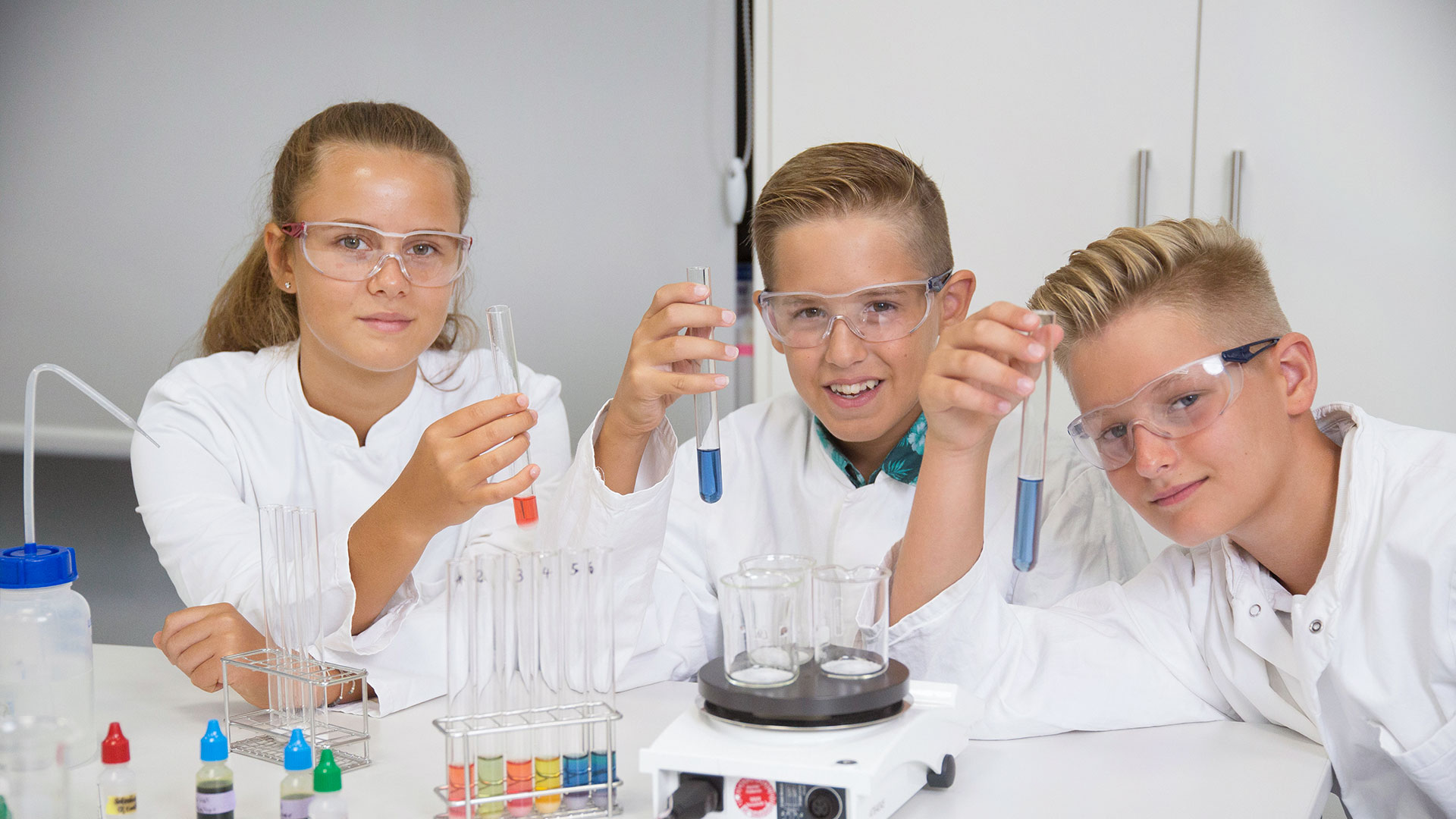 Drei jugendliche beim Chemieexperiment