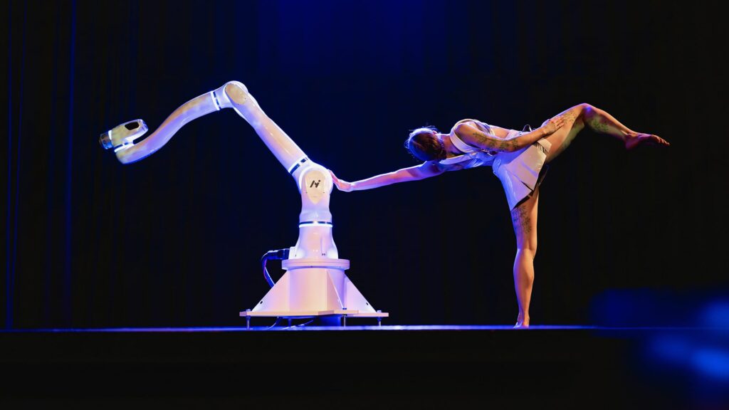 Roboter und Frau tanzen auf der Bühne