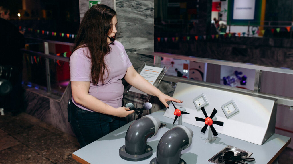 Eine Mitarbeiterin der experimenta erklärt ein Exponat zur Energieerzeugung in der Ausstellung „Energie“ in Kiew.