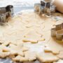 Ausgestochener Plätzchenteig mit Sternen, Bäumen und Lebkuchenmännern beim Plätzchen backen