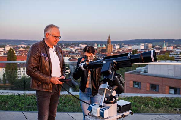 Sternwarte-Teamleiter Stephan Fichtner erklärt einer Besucherin die Himmelsbeobachtung zur Sonnenfinsternis in Heilbronn
