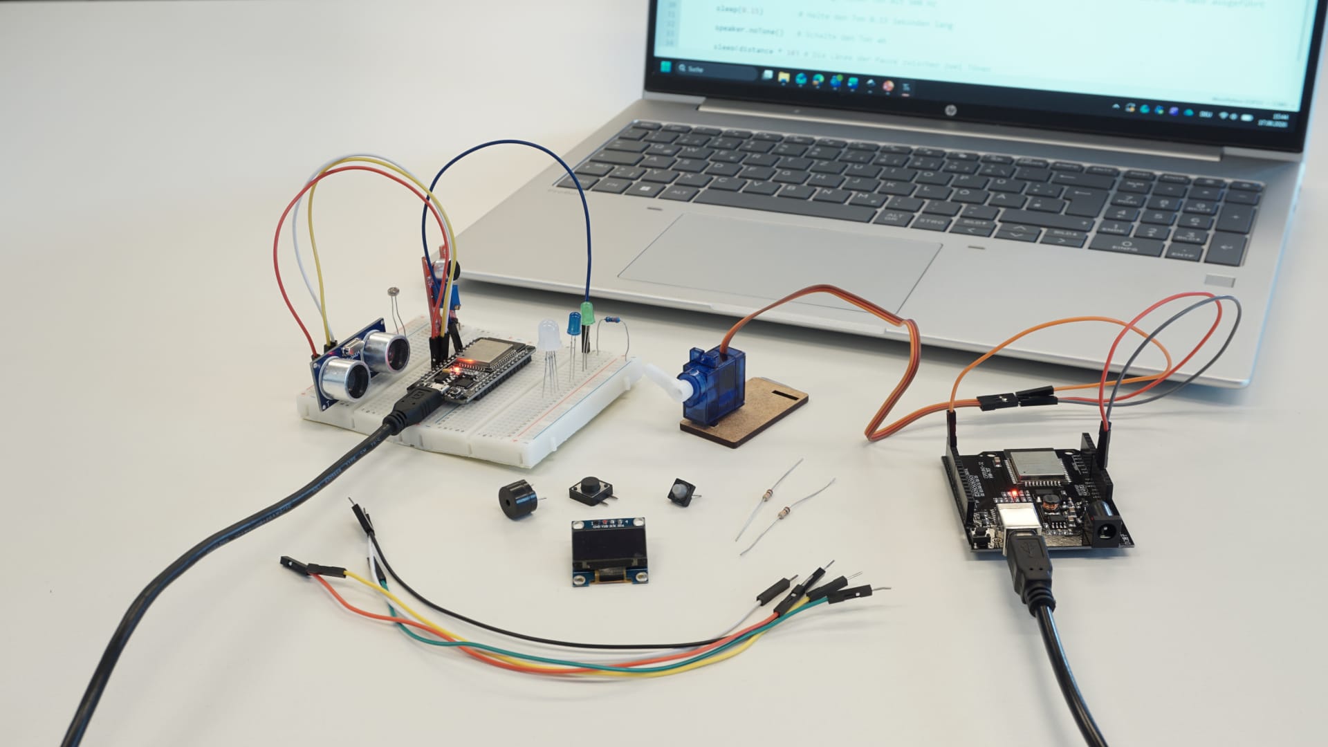 ESP32-Projekte_in_Python_experimenta_1920x1080 ESP32-Experimentieraufbau (Breadboard mit Sensoren, Laptop im Hintergrund): → ESP32-Experimentieraufbau mit Sensoren, LEDs, Servomotor und Laptop mit Python-Programmcode
